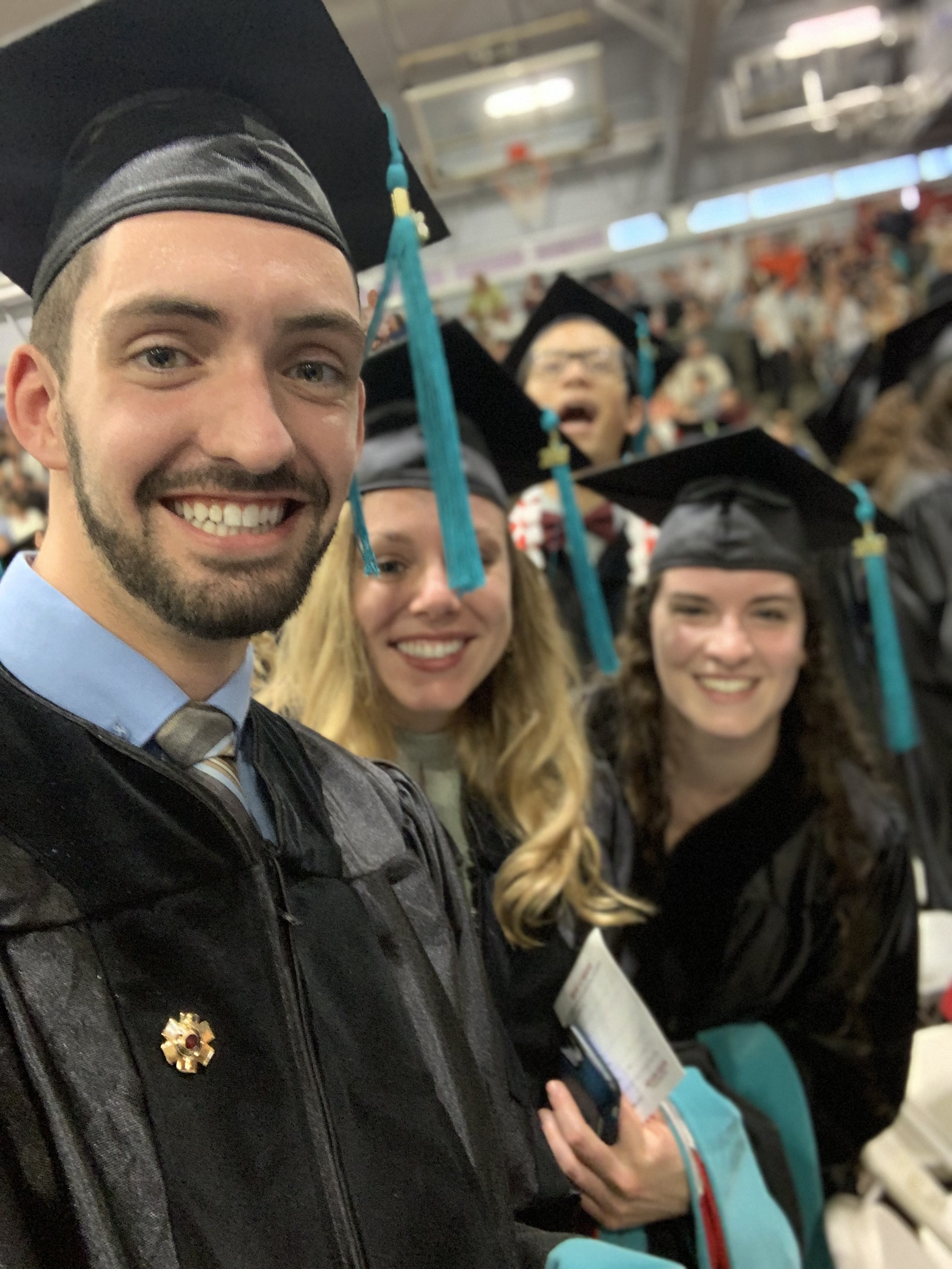 A photo of myself at my doctoral graduation with some of my classmates.